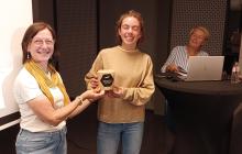 Twee vrouwen poseren met gewonnen prijs