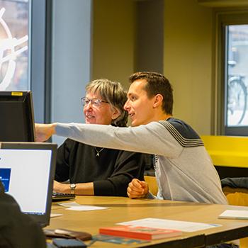 digihelper man toont vrouw iets op pc