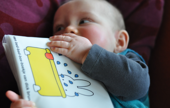 Baby sabbelt op knisperboekje