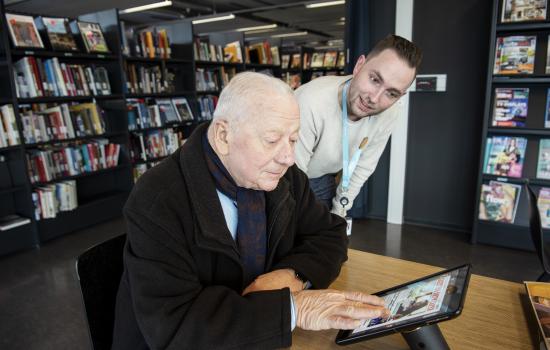 ARhus-medewerker helpt oudere man met tablet