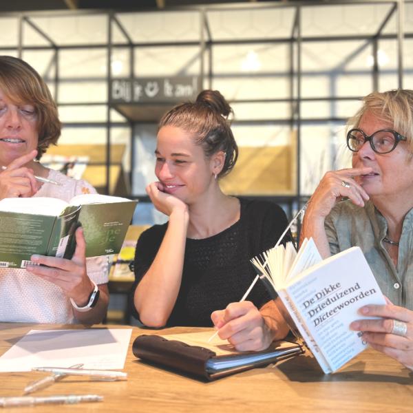 De Schrijfwijzen Drie vrouwen met taalboeken