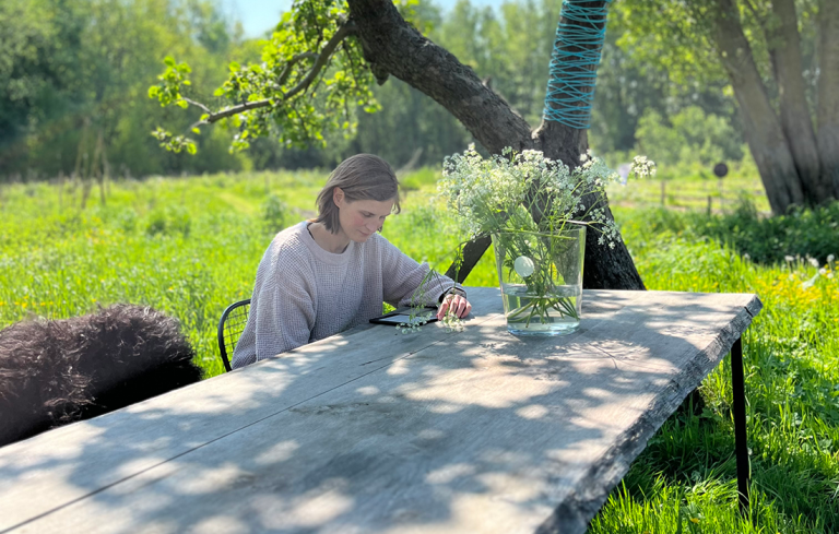 Vrouw leest boek aan tafel
